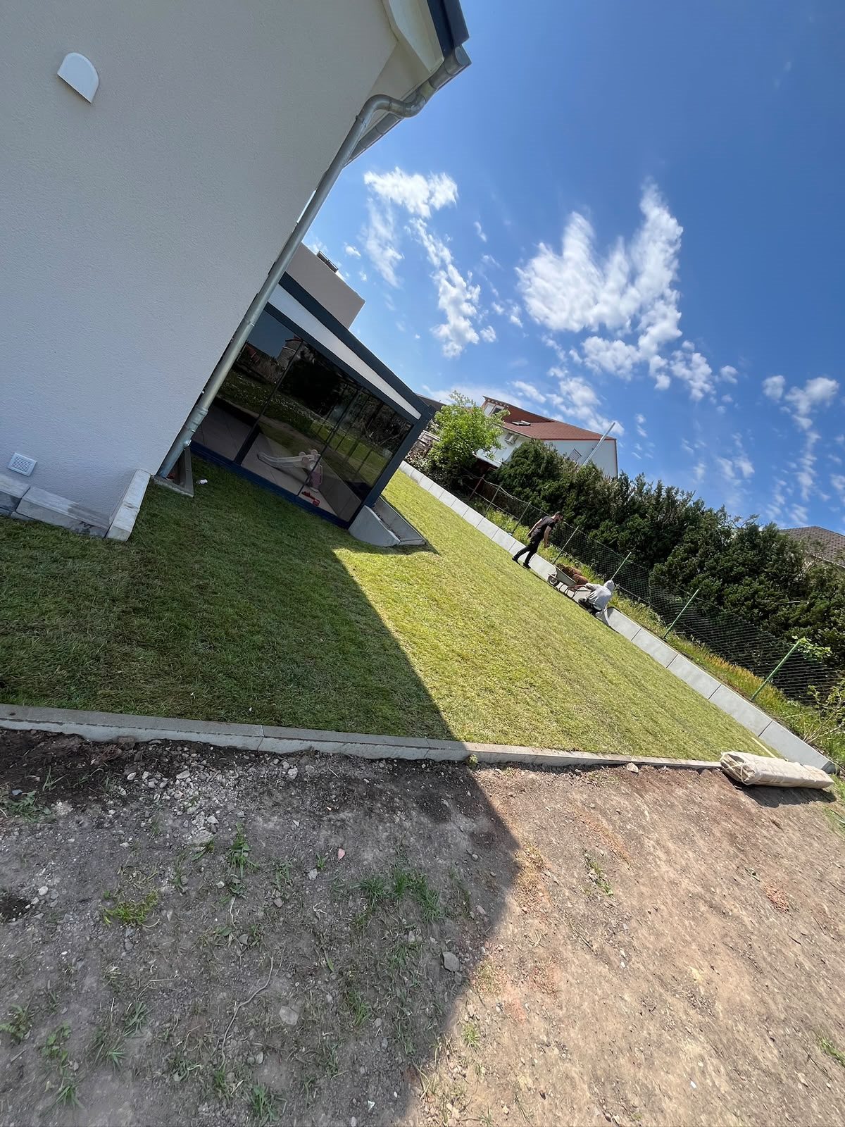 Neu angelegte Rasenfläche neben einem Wohnhaus.